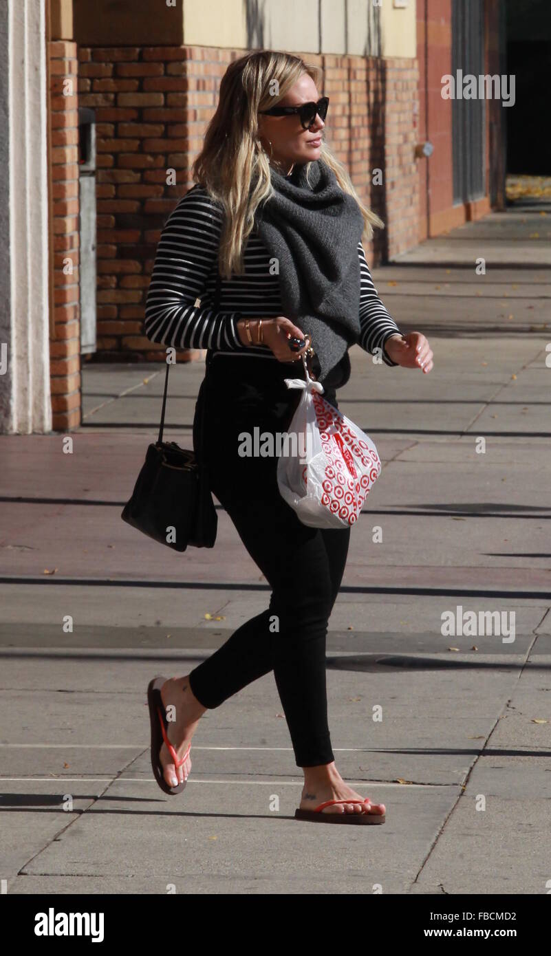 Hilary Duff shopping in Studio City wearing flip flops, black leggings and  a balck and white