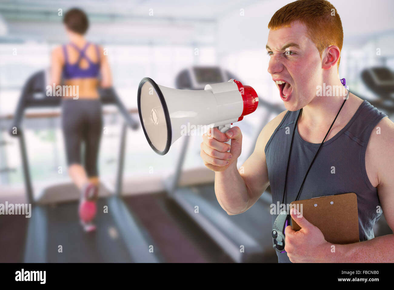 Composite image of angry personal trainer yelling through megaphone Stock Photo