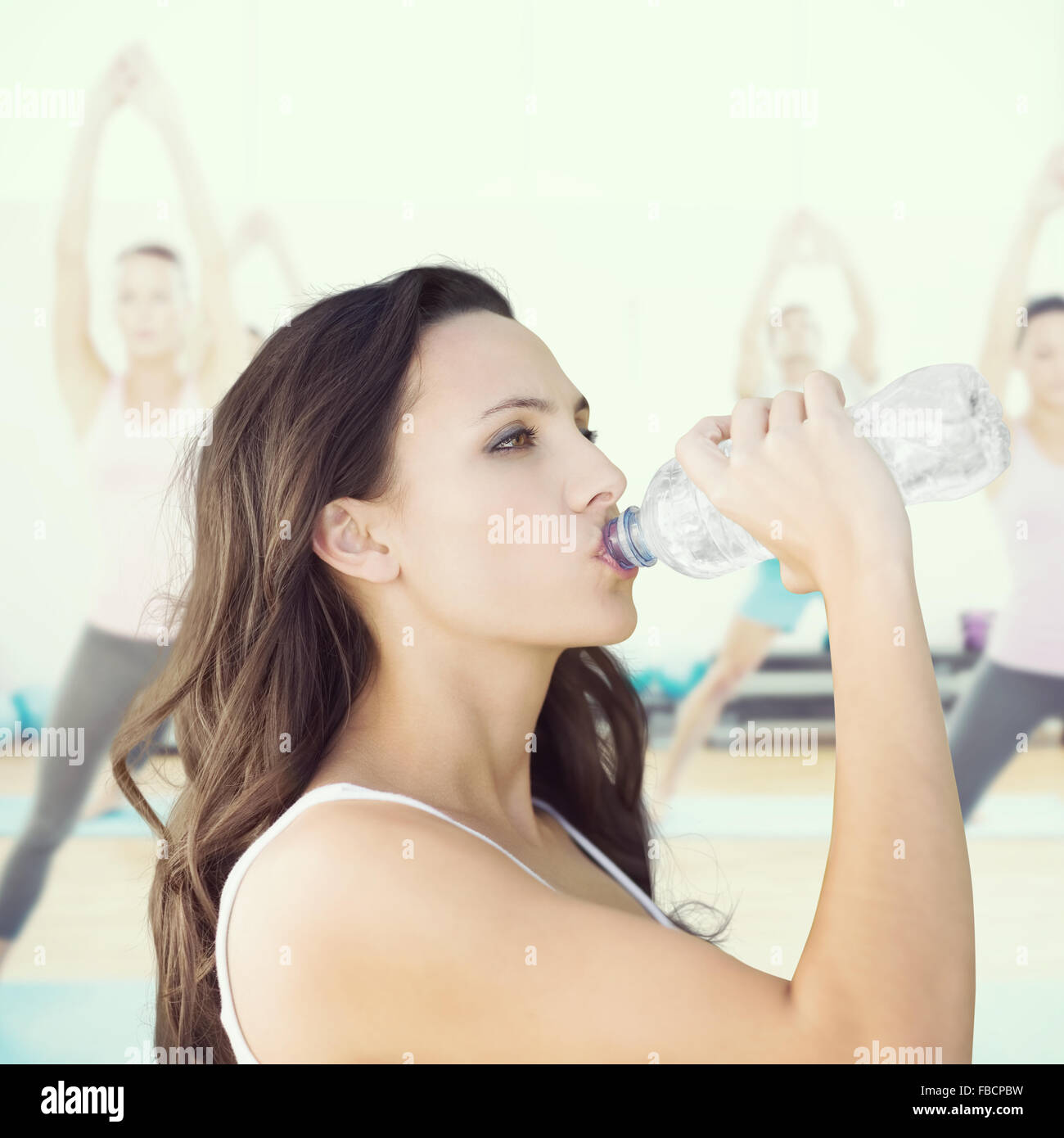 Composite image of beautiful woman drinking water from bottle Stock Photo