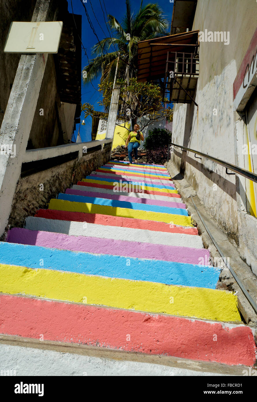 Woman walking down painted stairs in Acapulco, Mexico Stock Photo