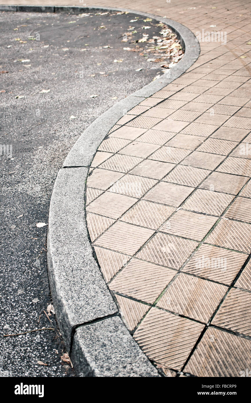 Part of a curved pavement next to a road Stock Photo Alamy