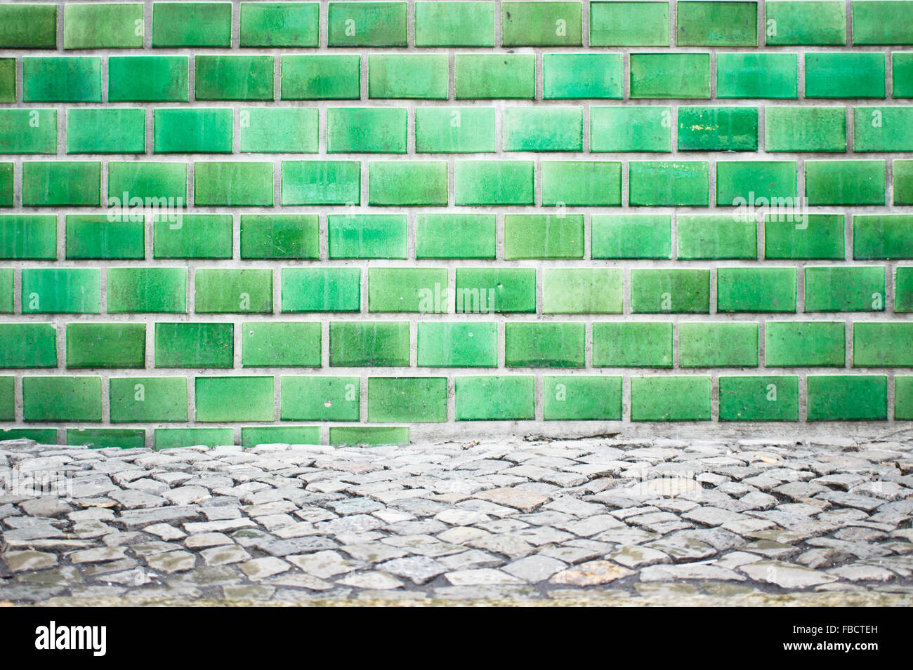 A wall of green tiles on the exterior of a building Stock Photo