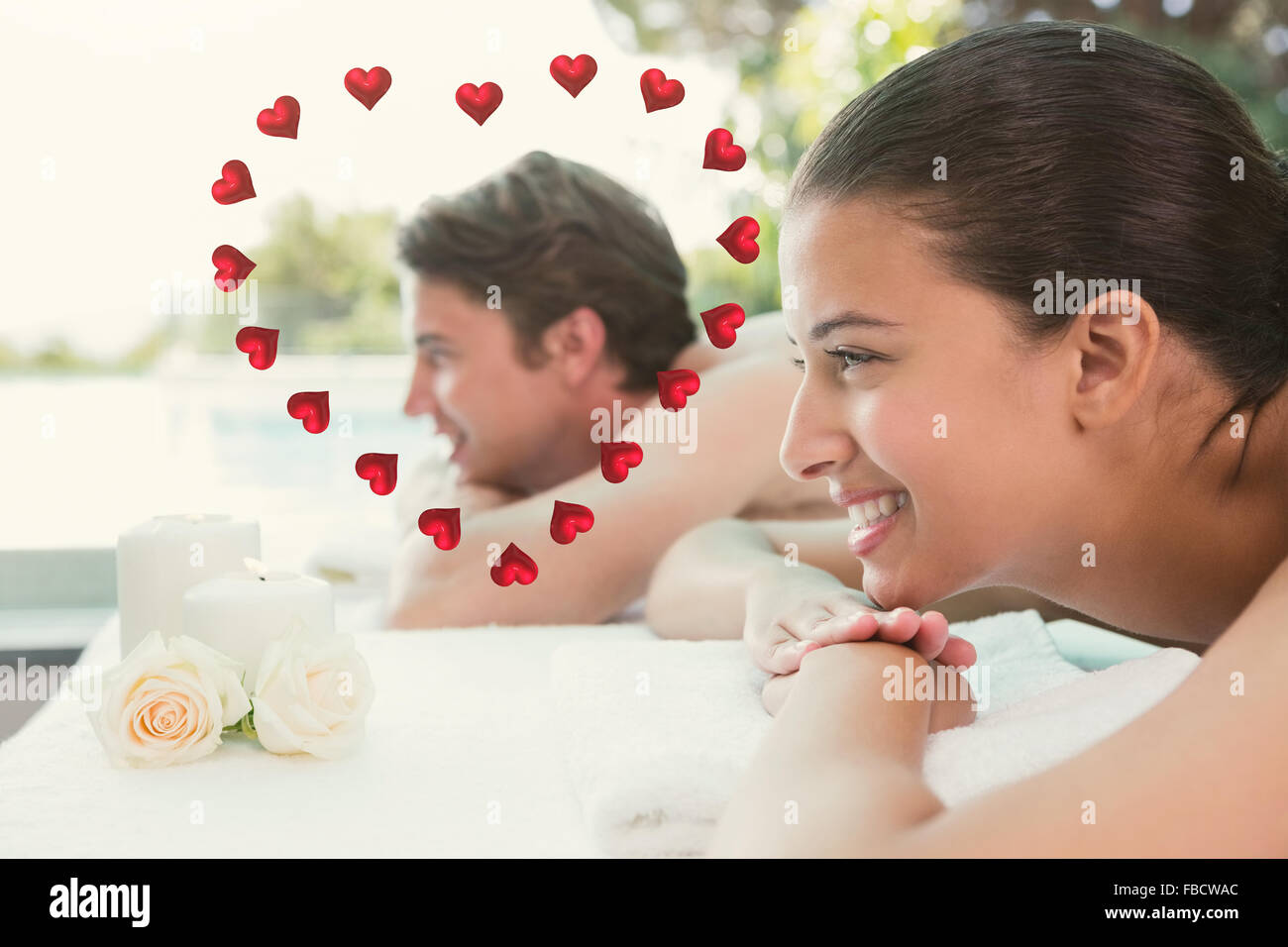 Composite image of couple lying on massage table at spa center Stock Photo