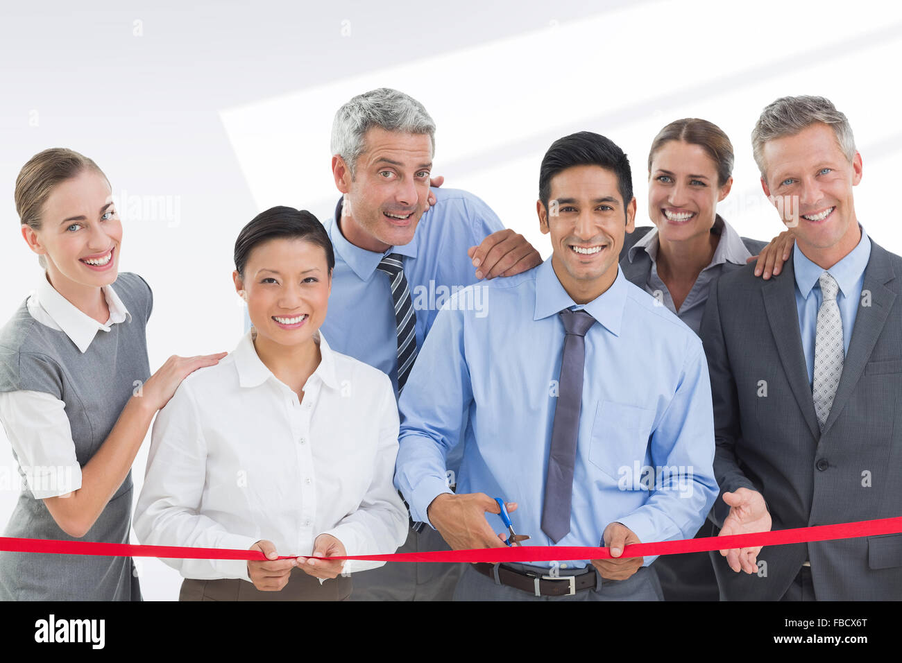 Composite image of business man cutting red strip Stock Photo