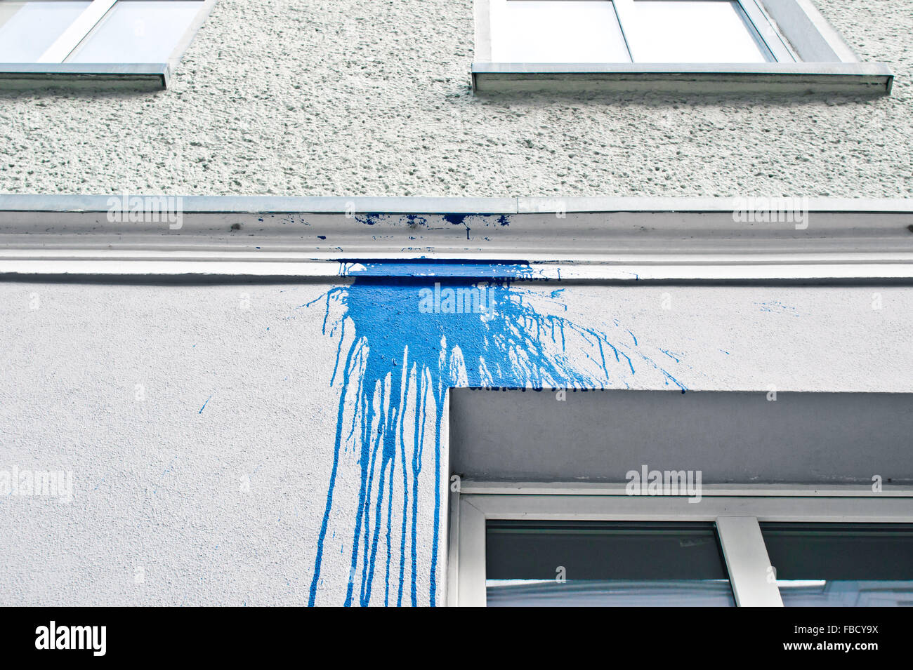 A stain from spilt blue paint on the exterior of a white building Stock Photo