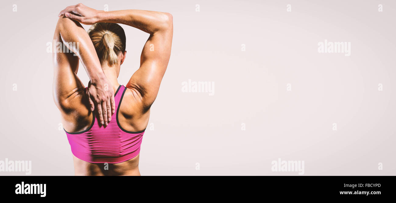 Composite image of muscular woman stretching her arms Stock Photo