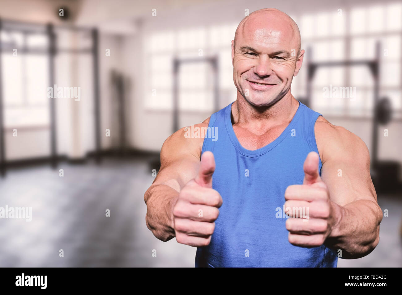 Composite image of smiling healthy man showing thumbs up Stock Photo