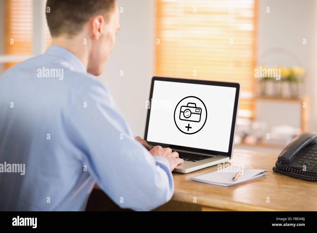 Composite image of businessman working on his laptop Stock Photo