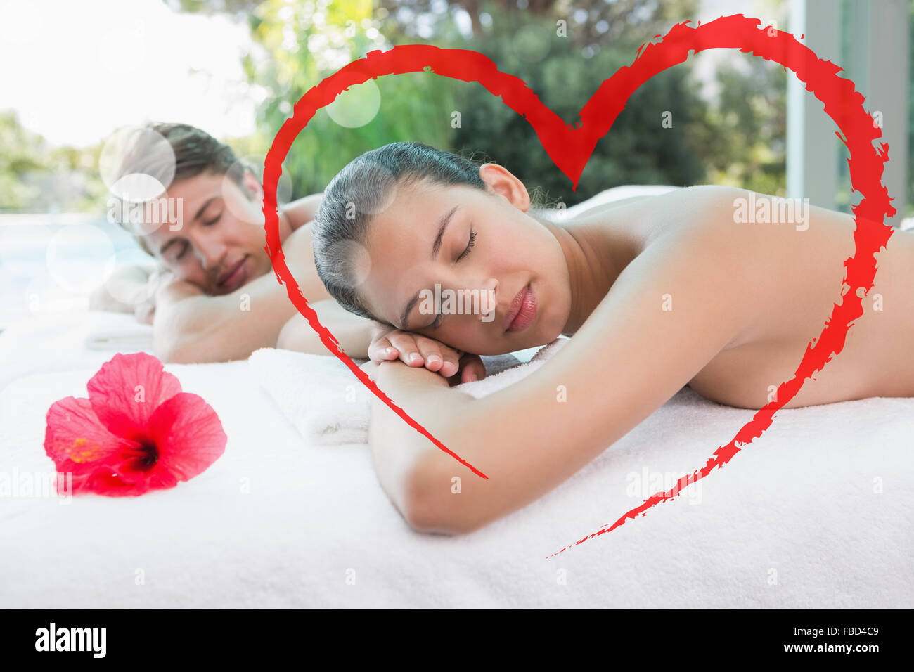 Composite image of couple lying on massage table at spa center Stock Photo