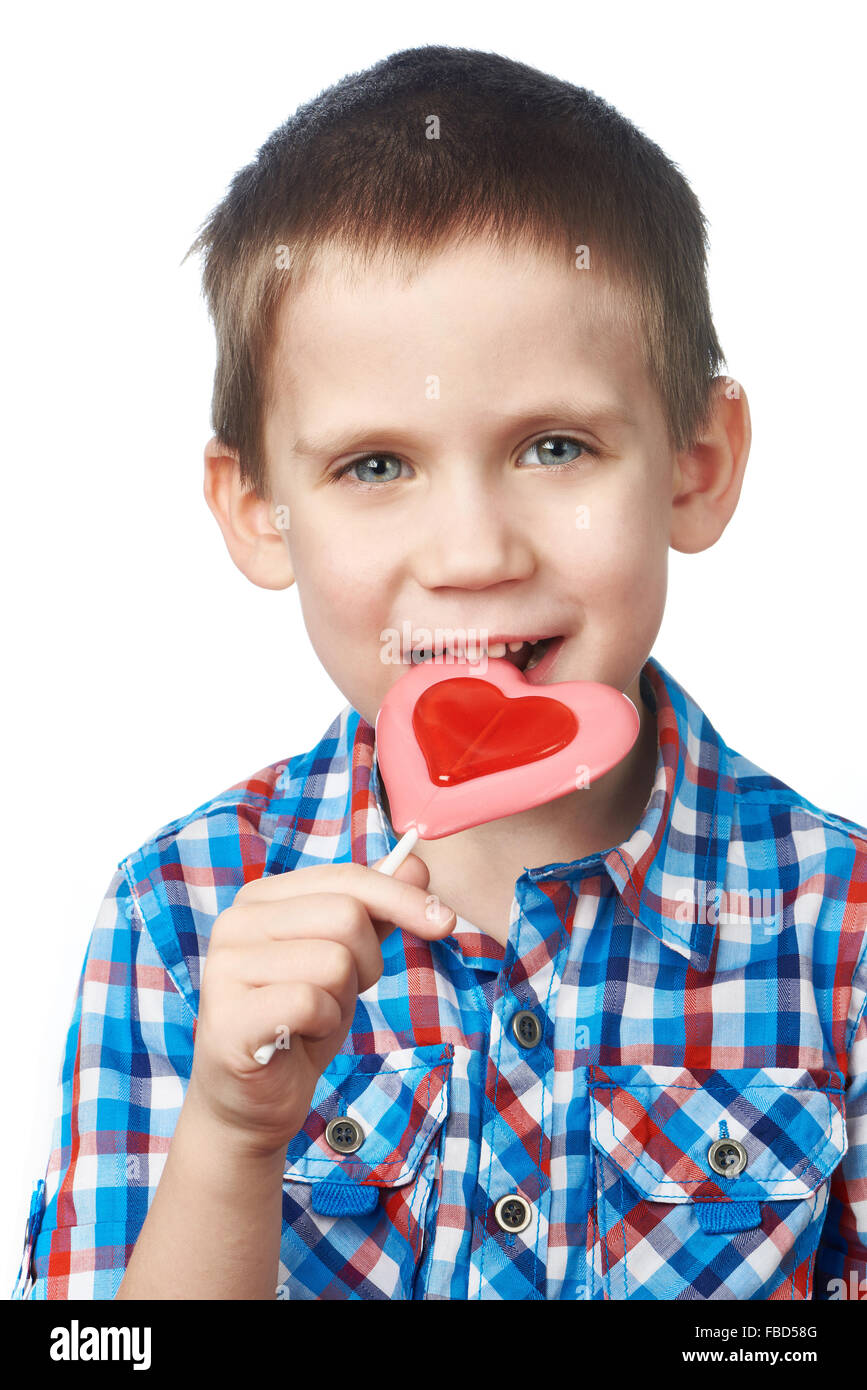 Little boy eating a lollipop heart isolated Stock Photo