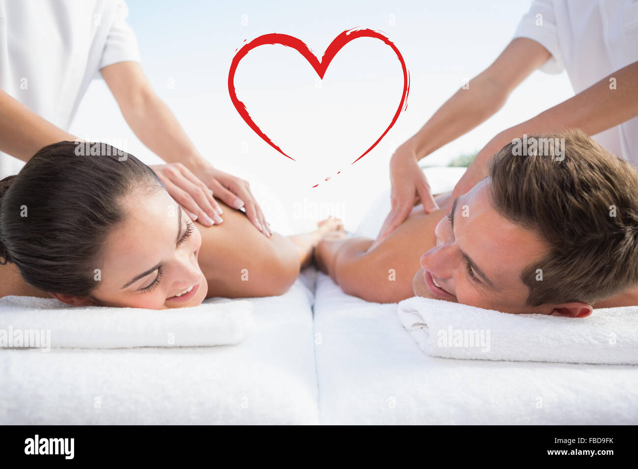 Composite image of peaceful couple enjoying couples massage poolside Stock Photo