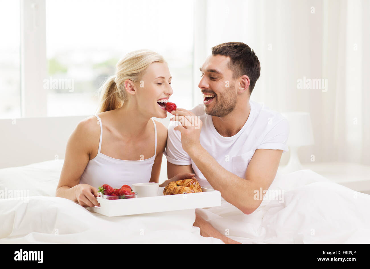 happy couple having breakfast in bed at home Stock Photo Alamy