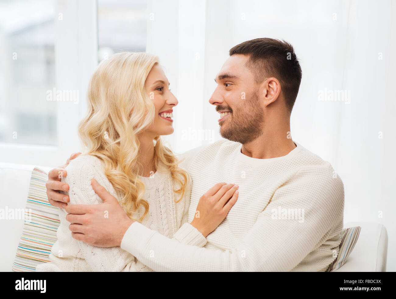 happy couple hugging on sofa at home Stock Photo - Alamy