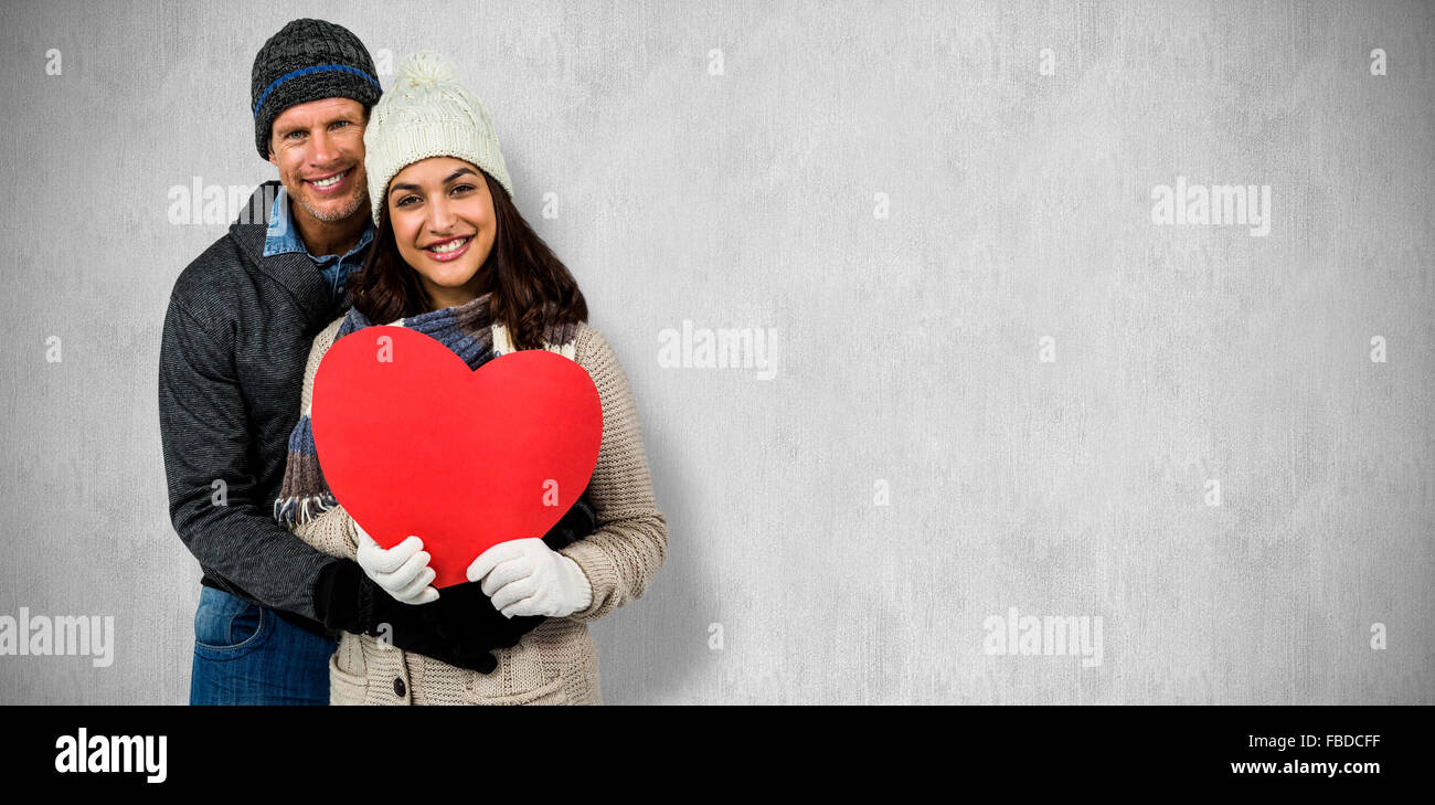 Composite image of festive couple in winter clothes Stock Photo