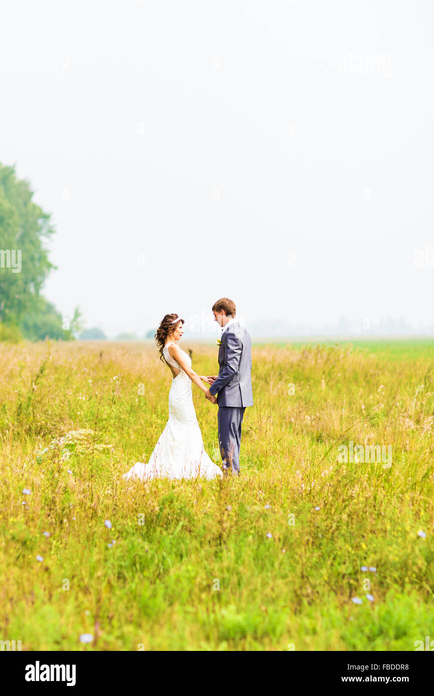Young happy wedding couple holding hands Stock Photo - Alamy