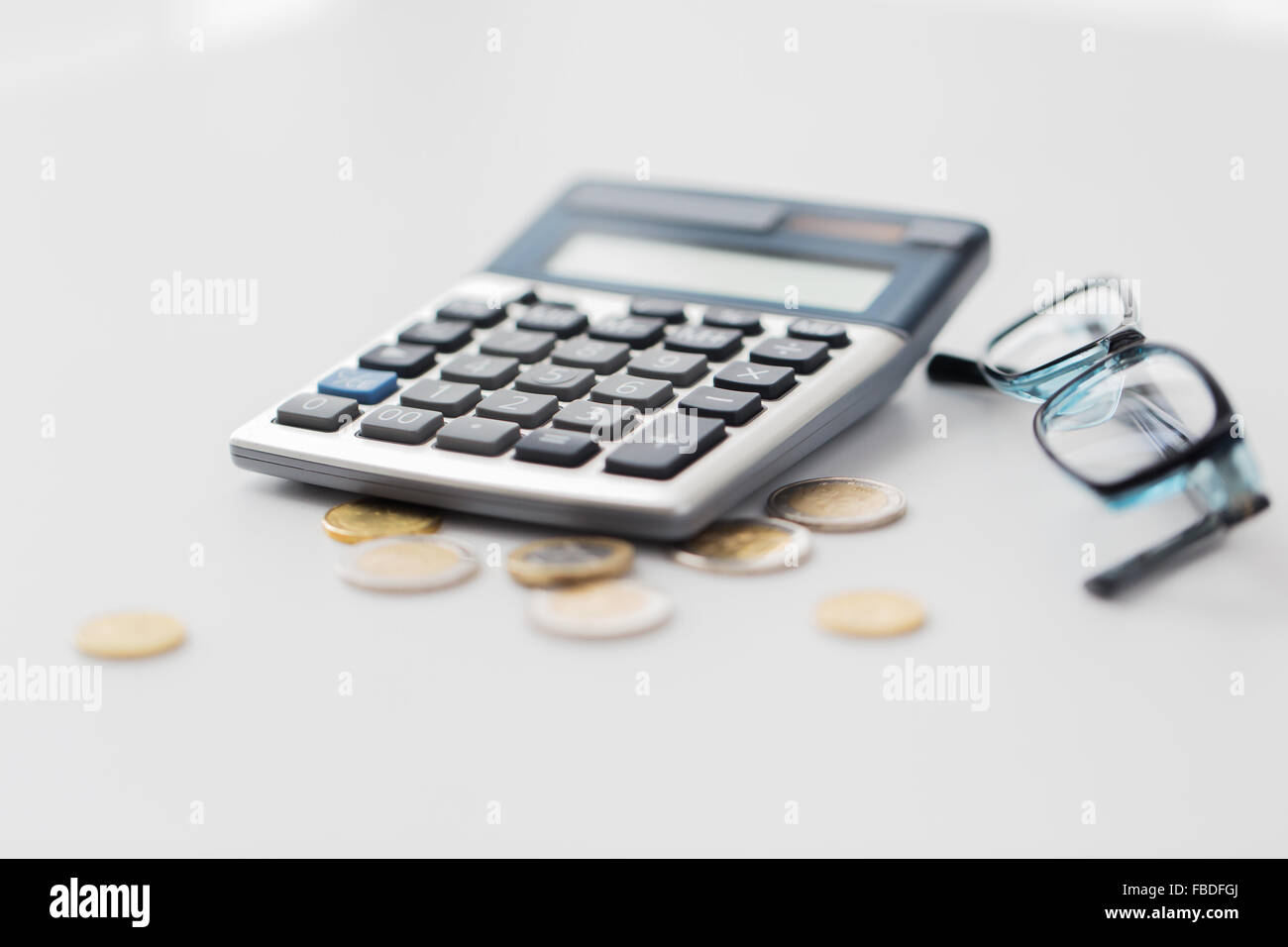 calculator, eyeglasses and coins on office table Stock Photo Alamy