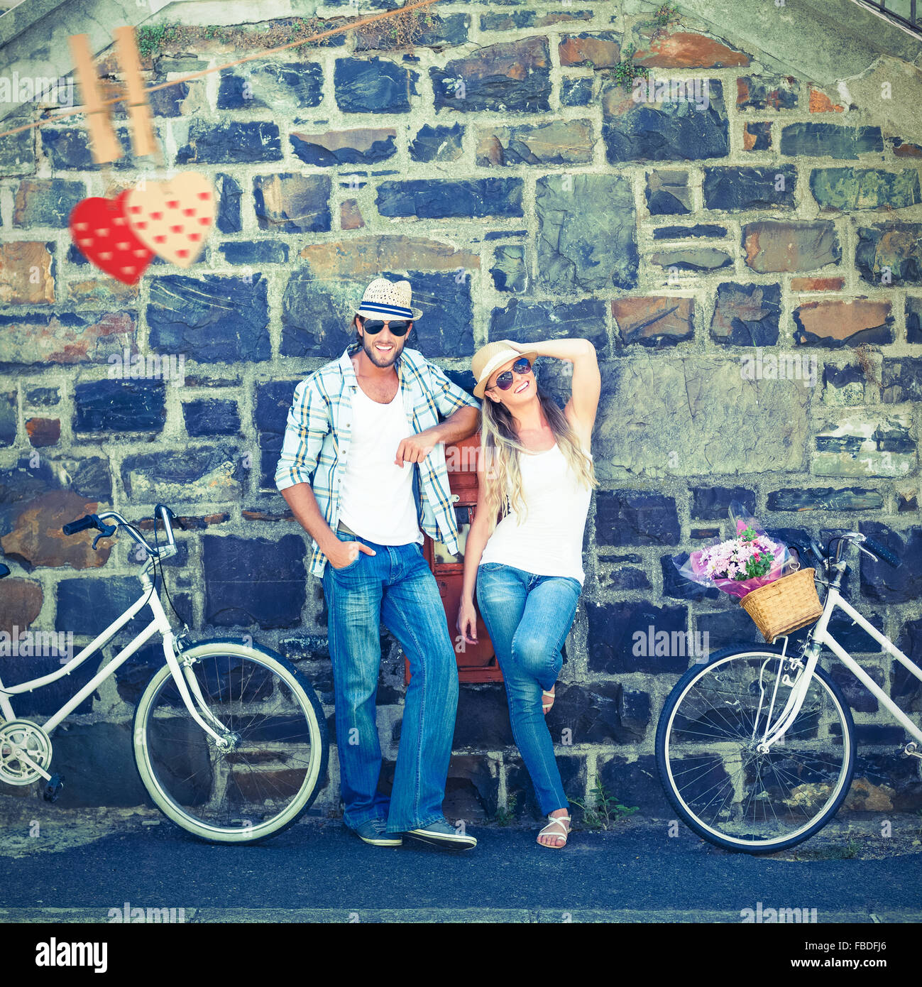 Composite image of attractive couple standing with bikes Stock Photo