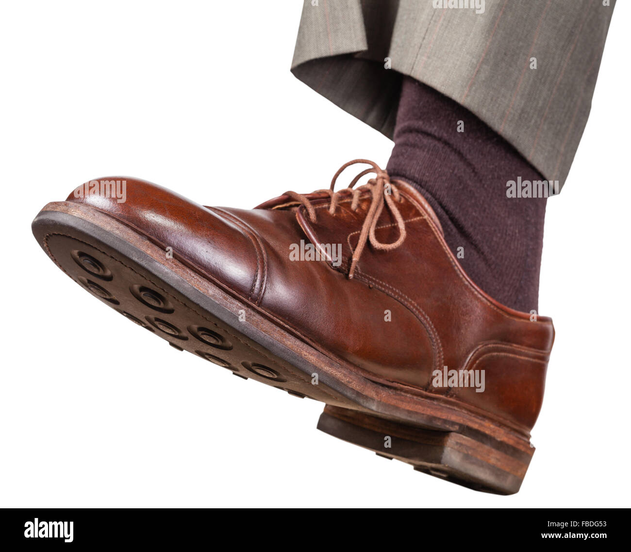 male left foot in brown shoe takes a step isolated on white background Stock Photo