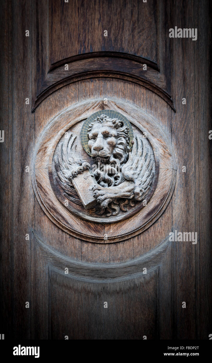 The winged lion of St. Mark, the symbol of the Venetian Republic, engraved on a portal of an old church. Stock Photo
