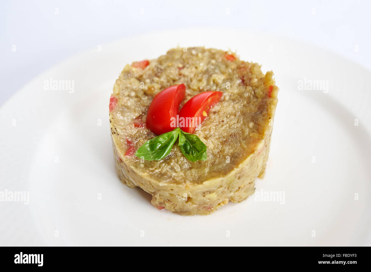 Eggplant Caviar on white plate studio shot Stock Photo