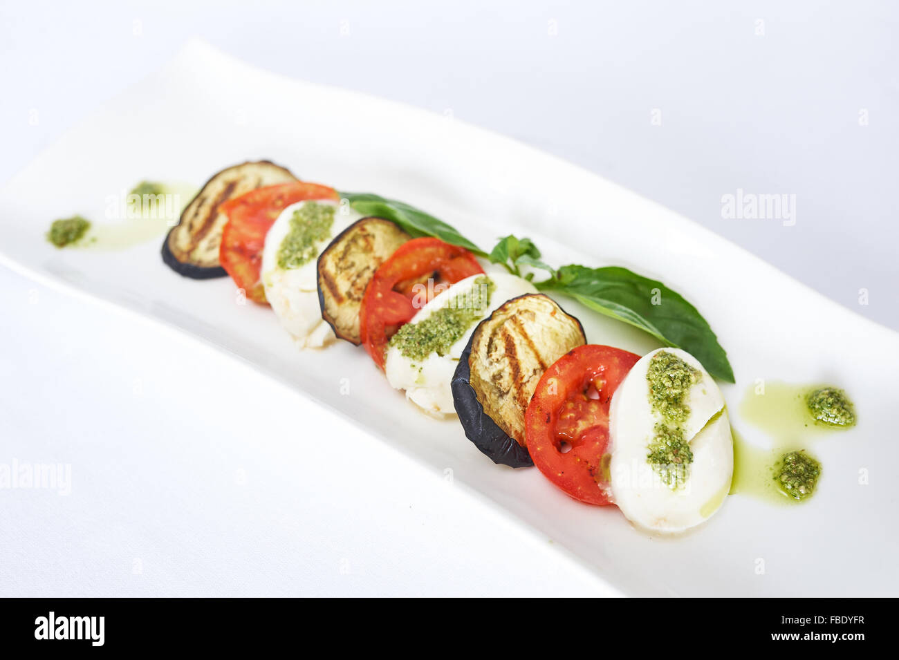 Grilled vegetables with mozzarella on white plate studio shot Stock Photo
