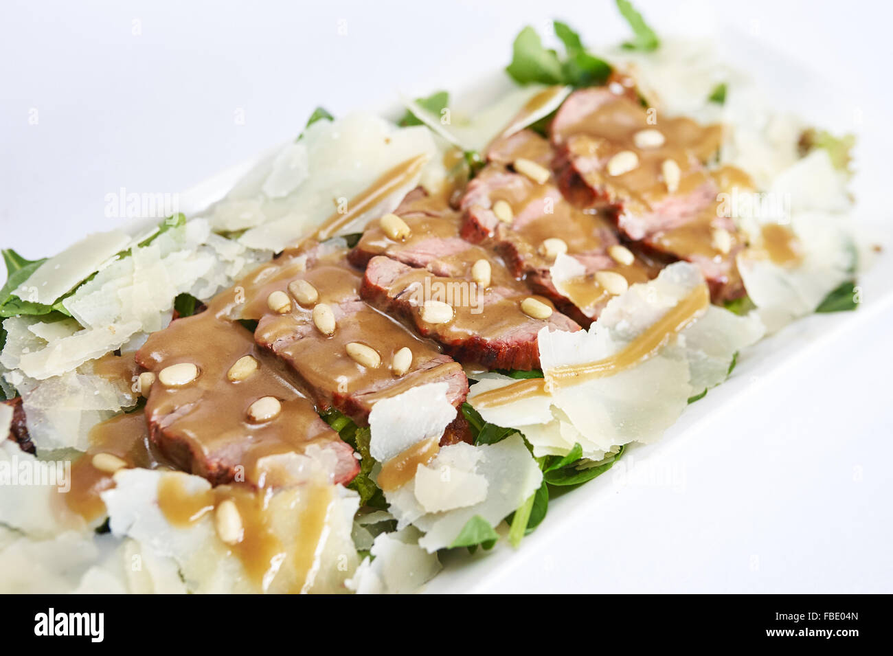 Salad with veal on white plate studio shot Stock Photo