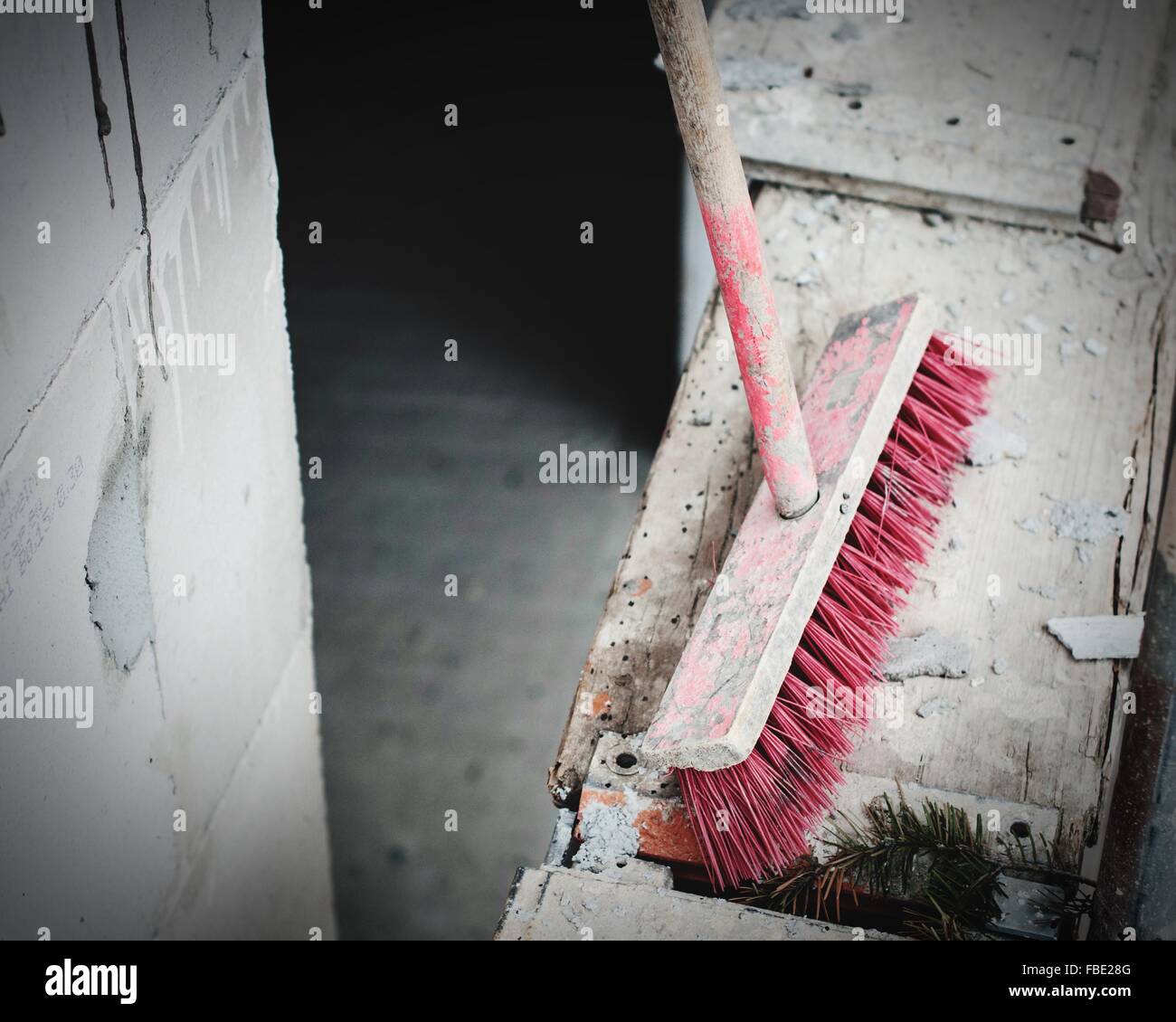 High Angle View Of Messy Broom On Wood By Wall Stock Photo