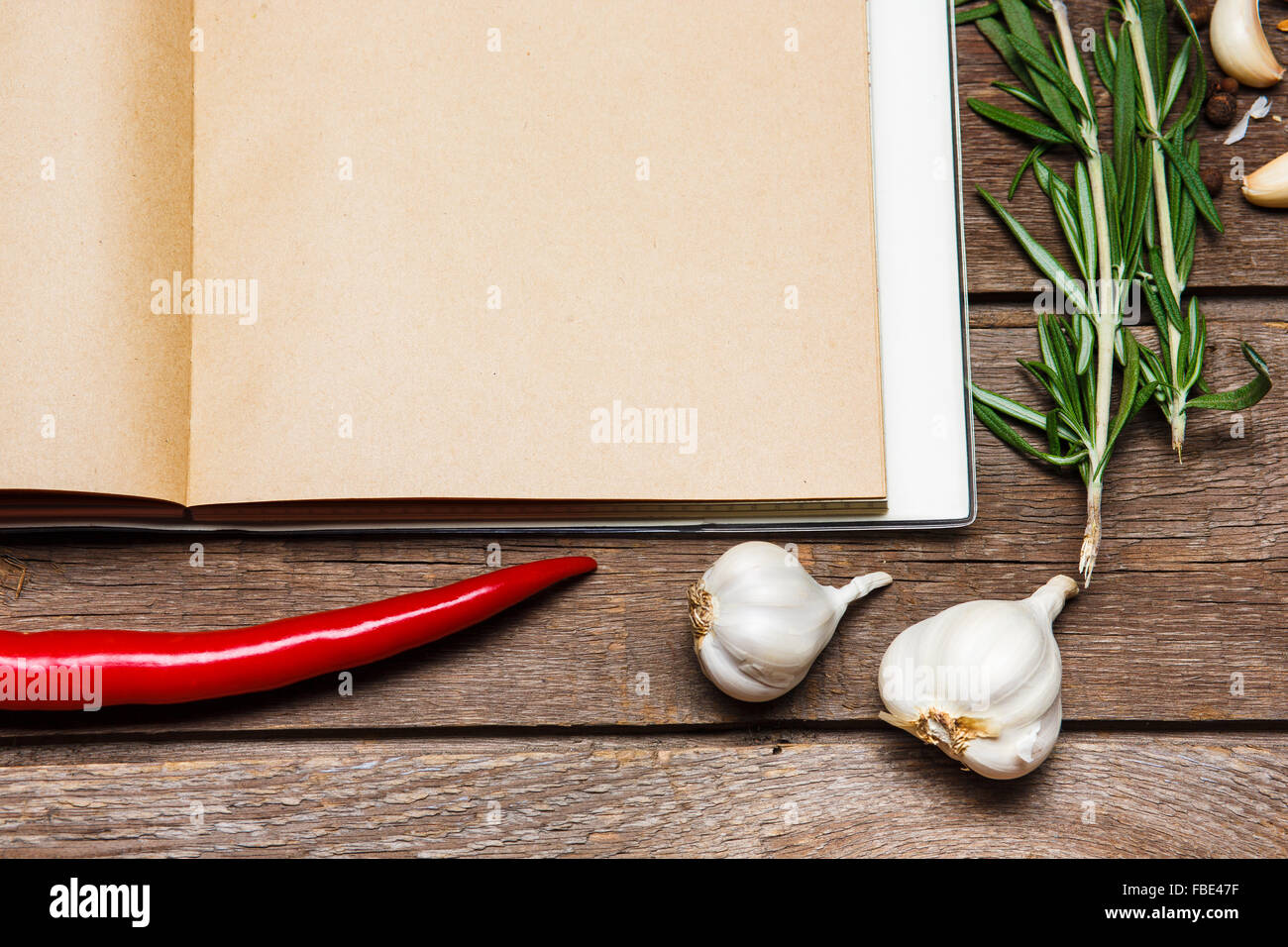 https://c8.alamy.com/comp/FBE47F/open-blank-recipe-book-on-brown-wooden-background-wits-garlic-red-FBE47F.jpg