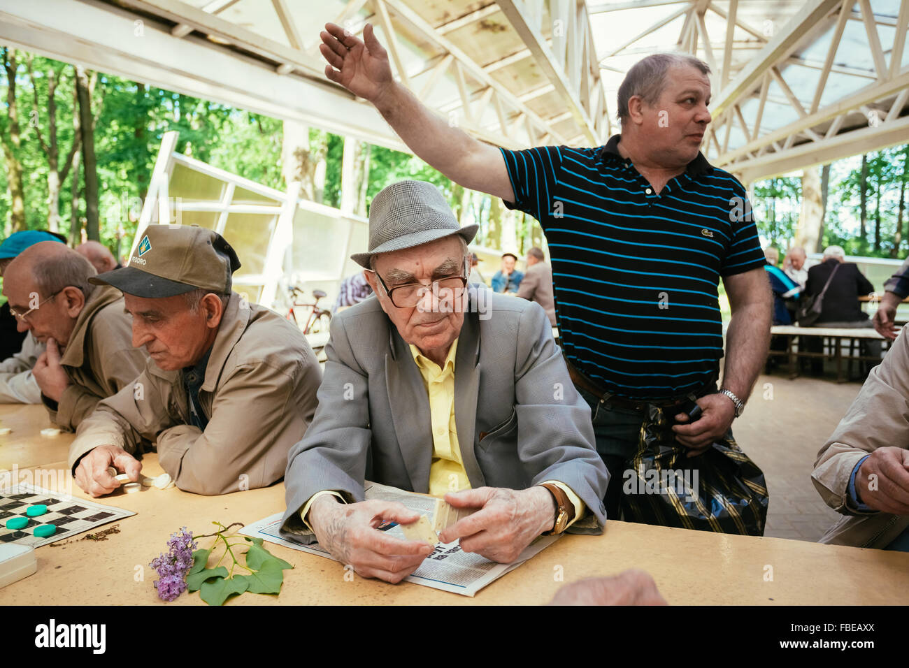 BELARUS, GOMEL - MAY 9, 2014: Active retired people, old friends and free time, senior men having fun and playing chess at city Stock Photo