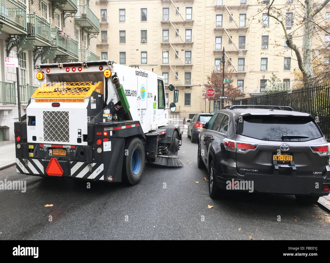 Cars on Manhattan's Upper East Side give way for a street sweeper