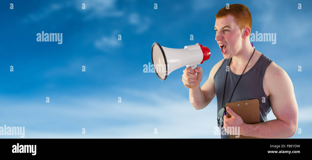 Composite image of angry personal trainer yelling through megaphone Stock Photo