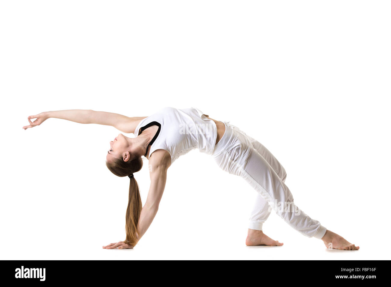 Young fitness model in white sportswear doing yoga or pilates training, exercise bridge, asana Camatkarasana, Wild Thing, Dancin Stock Photo