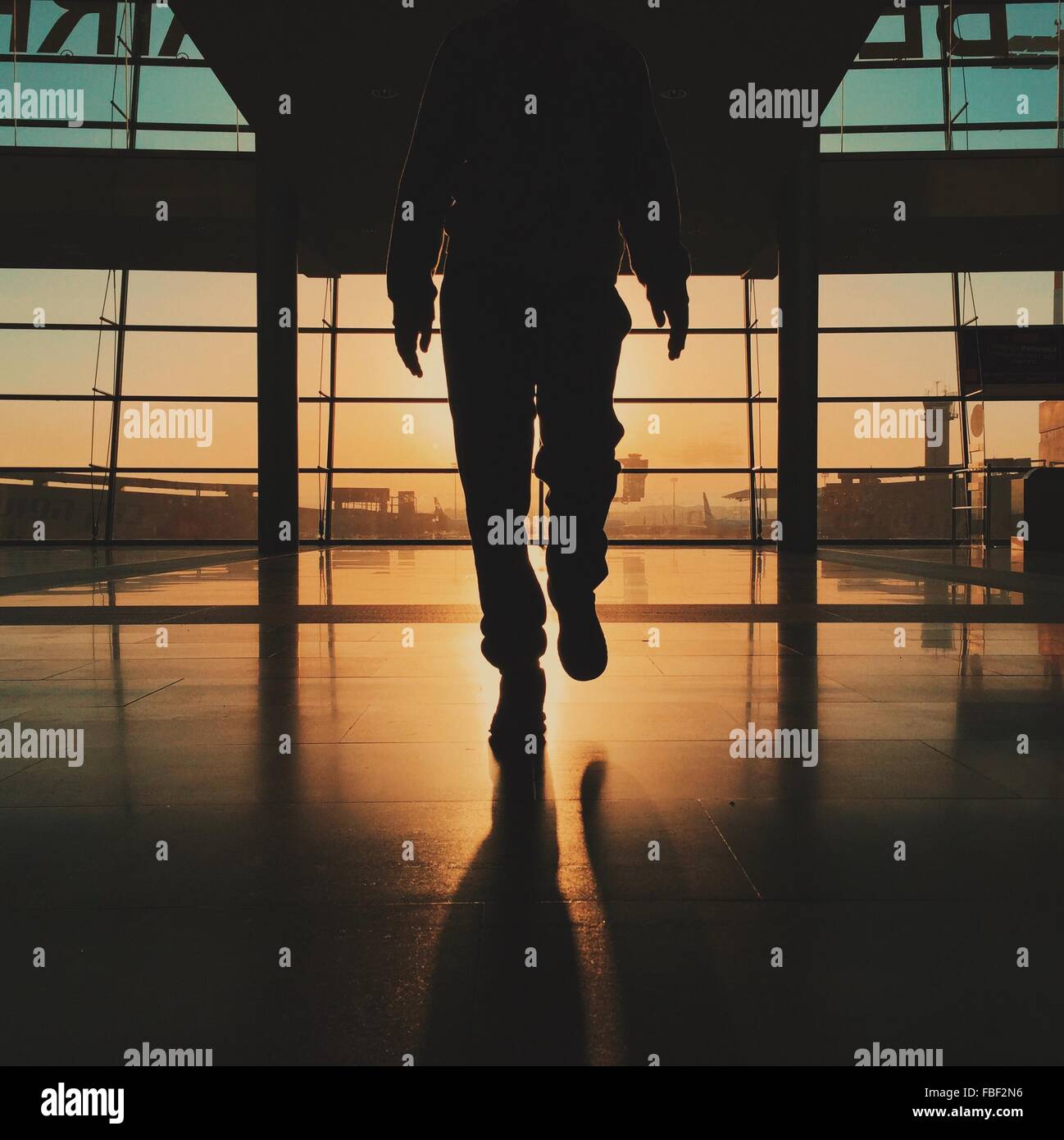 Low Section Of Silhouette Man Walking At Airport Stock Photo