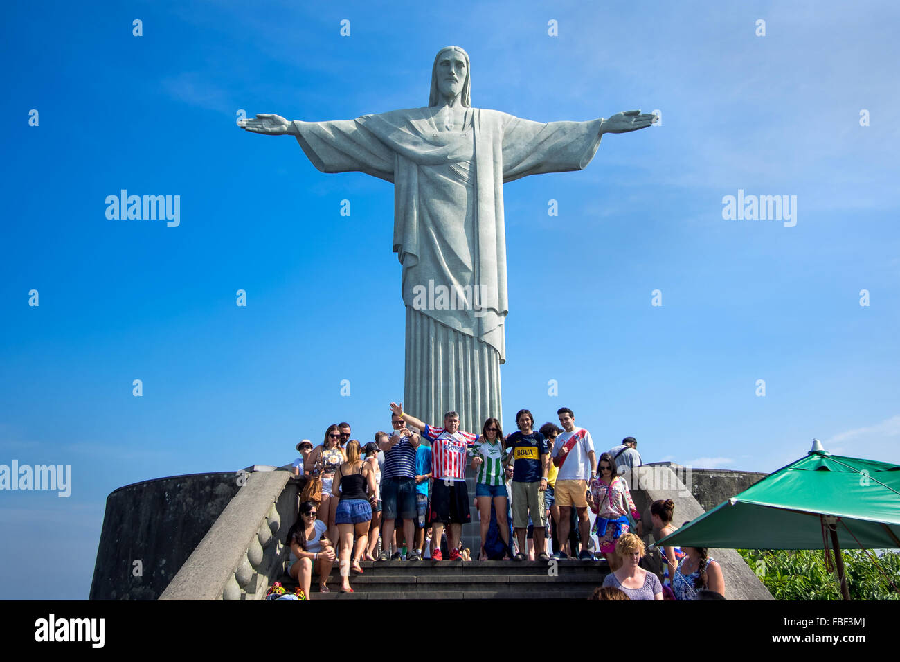 Tourists posing in front of famous Christ the Redeemer statue atop the Corcovado mountain in Rio de Janeiro, Brazil. Stock Photo