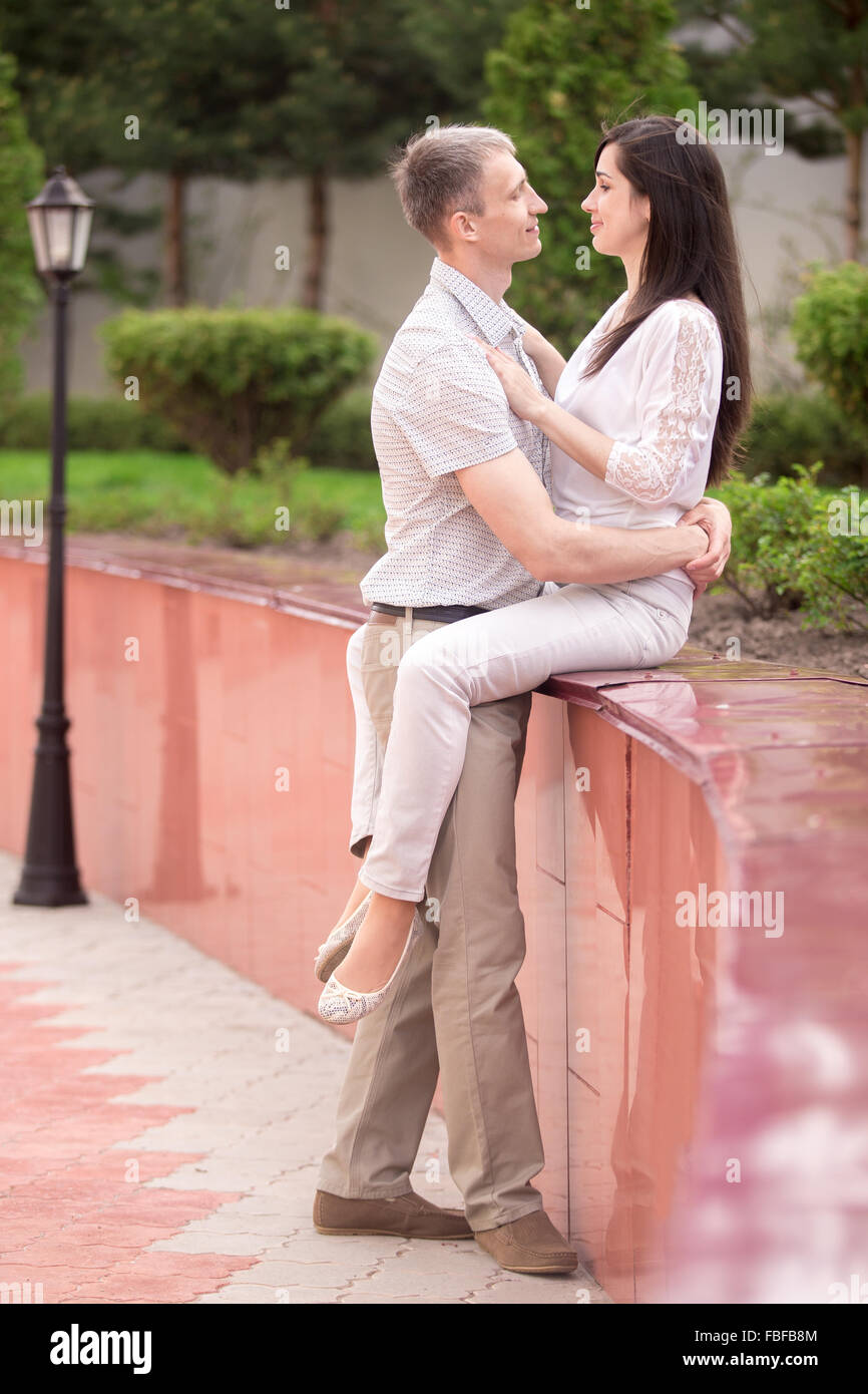 Portrait of happy couple, young man and woman in love on romantic date, sitting face to face in park, looking in each other eyes Stock Photo