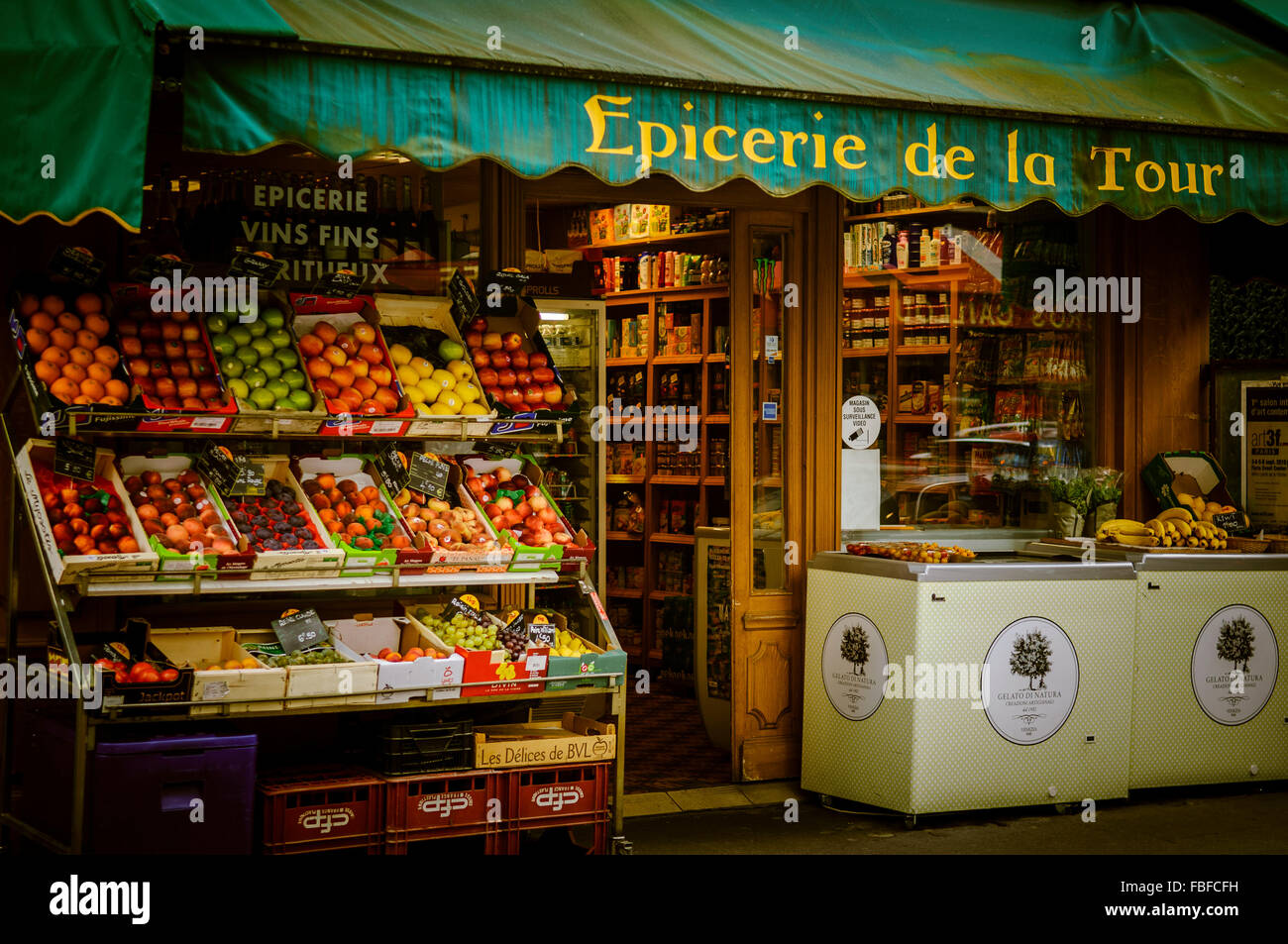 A vibrant, colourful, image of a grocery store, in Paris, with fresh fruit set out on the street