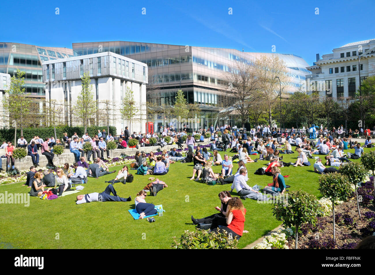Office workers and tourists relaxing in the sunshine at Festival Gardens by St Paul's Cathedral, City of London, UK Stock Photo