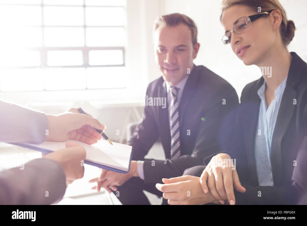 Colleagues signing a document Stock Photo - Alamy