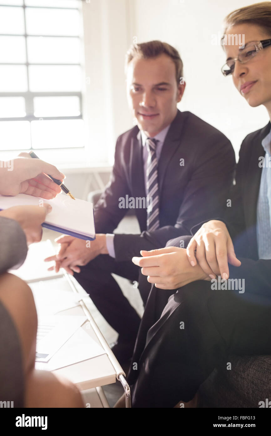 Colleagues signing a document Stock Photo - Alamy