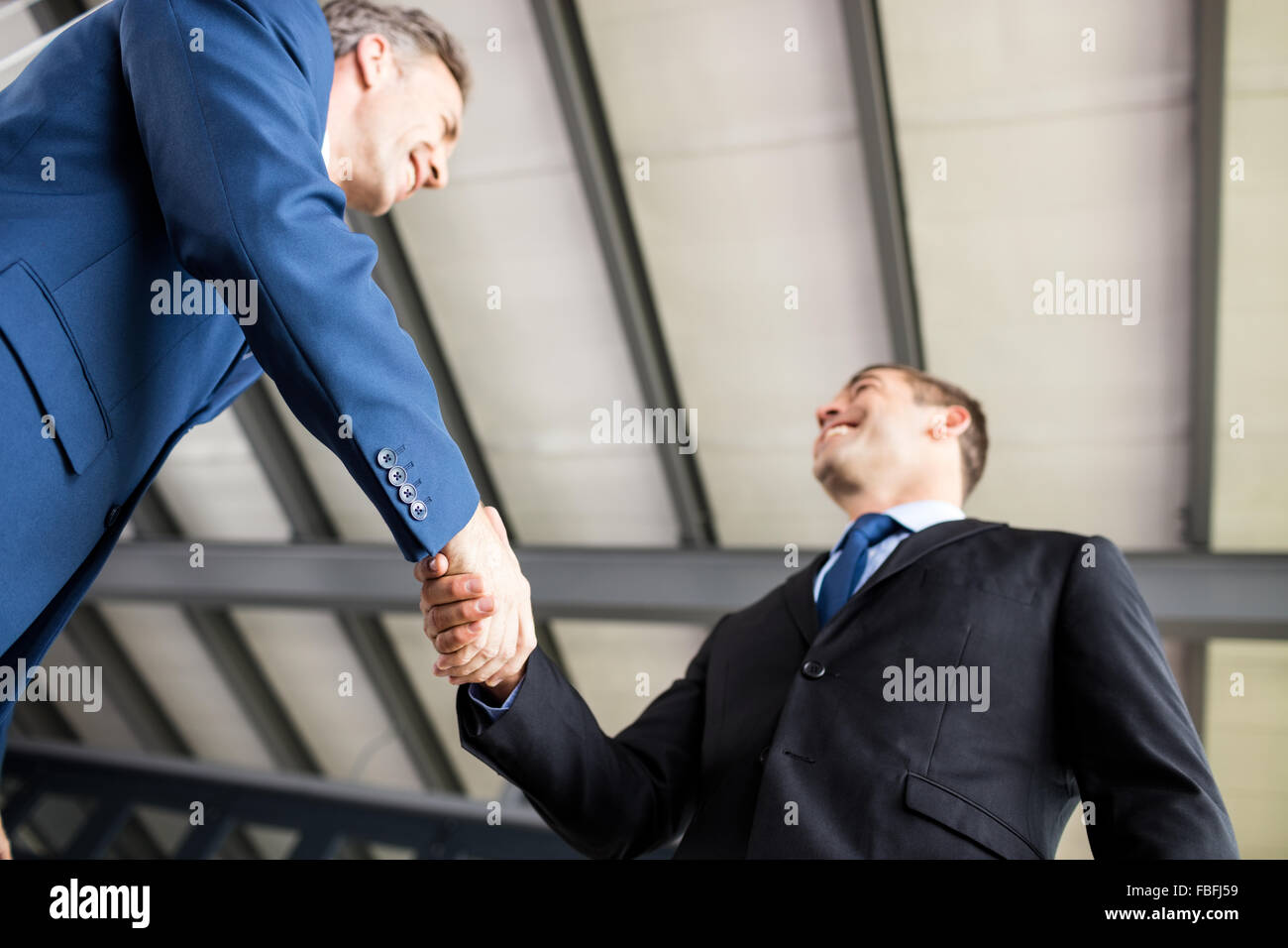 Two smiling businessmen shaking hands Stock Photo