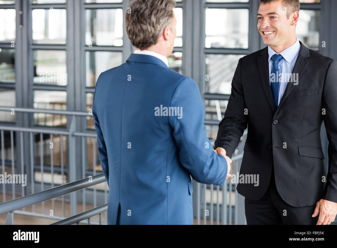Two smiling businessmen shaking hands Stock Photo