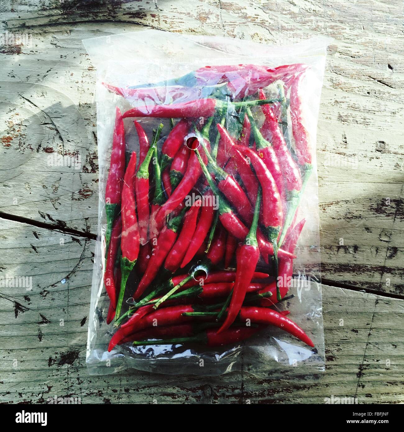 High Angle View Of Red Chili Peppers In Bag On Table Stock Photo