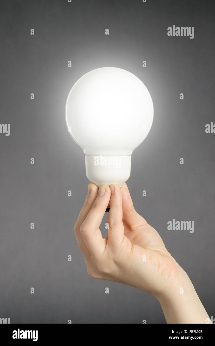 Hand holding a glowing light bulb Stock Photo - Alamy