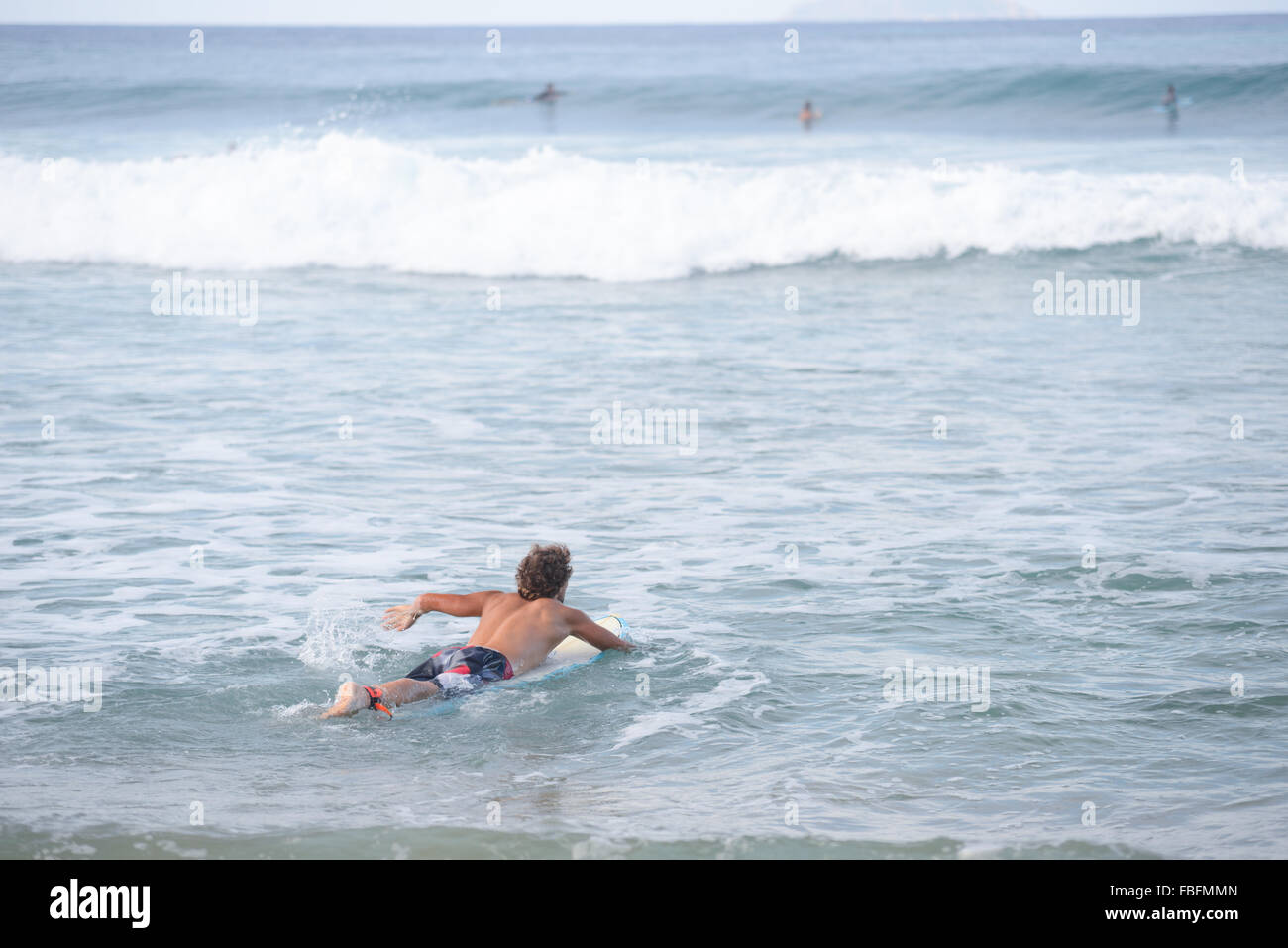 Male surfer surfing towards waves at Dome's Beach. Rincon, Puert Rico. USA territory. Caribbean Island. Stock Photo