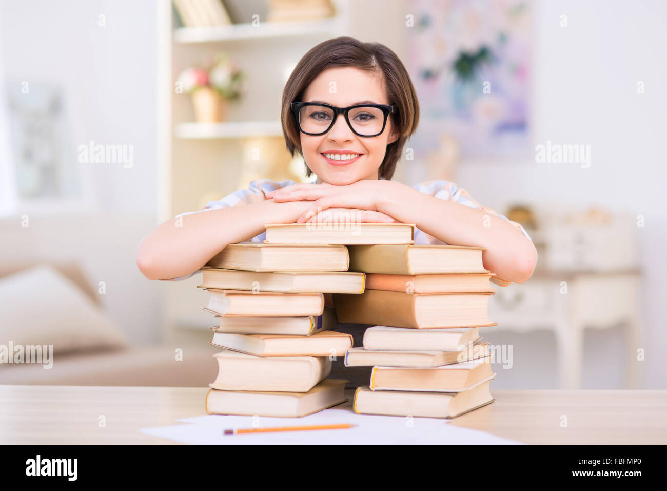 Young attractive girl is leaning on pile of books Stock Photo - Alamy