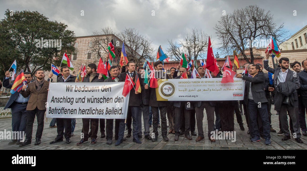 Members of the tourism association with international flags and a banner with a German sentence reading «We bemoan the attack and express our condolences to the relatives.» («Wir bedauern den Anschlag und wuenschen den Angehoerigen herzliches Beileid») at the site of a suicide bombing in the Sultanahmet district of central Istanbul, Turkey, early January 14, 2016. A suicide bombing there on January 12 killed ten German tourists and wounded several others. Photo: Peter Kneffel/dpa Stock Photo