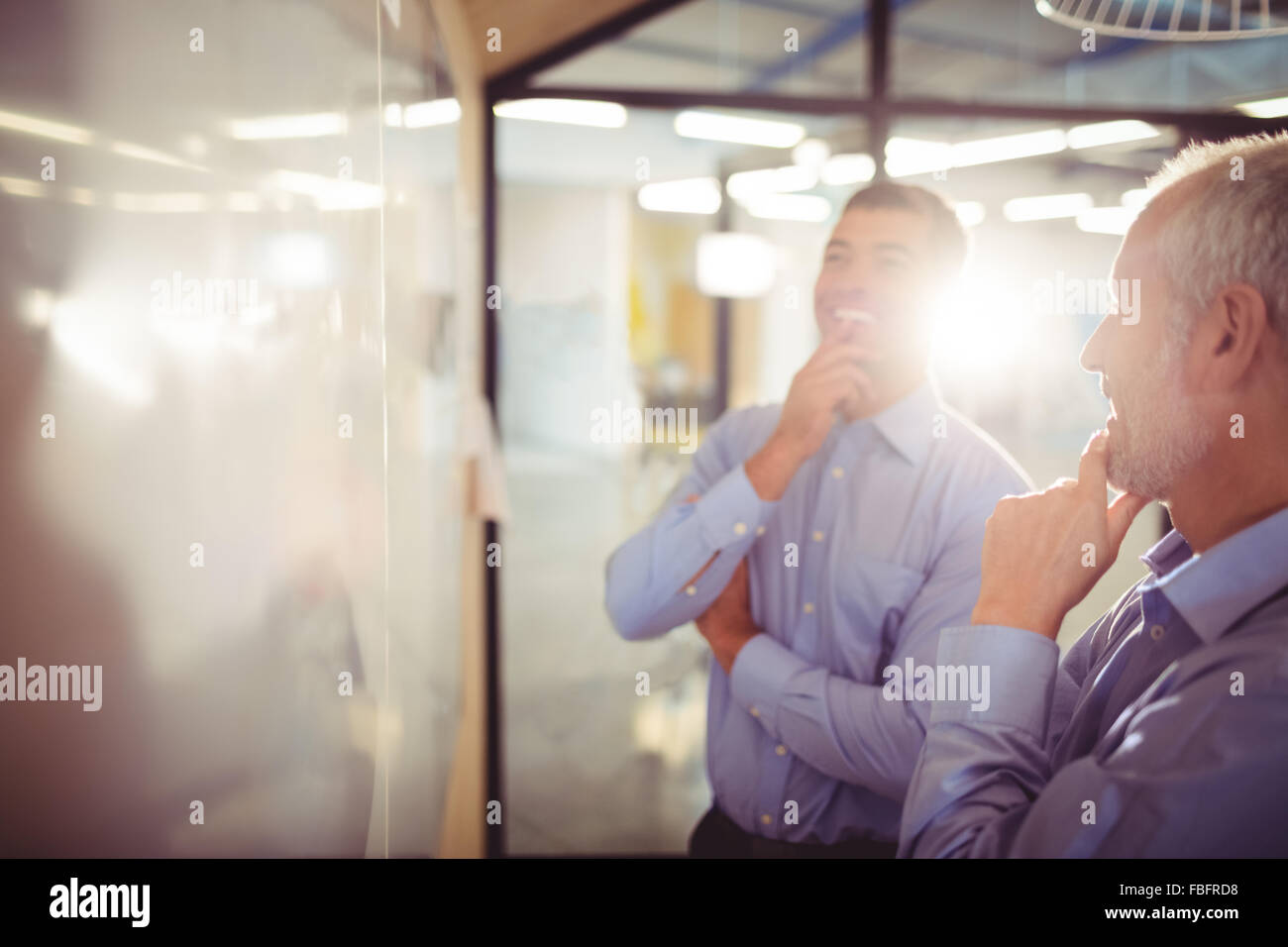 Businessman with hand on chin Stock Photo
