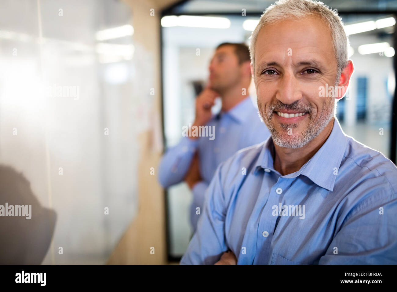 Smiling businessman with arms crossed Stock Photo - Alamy
