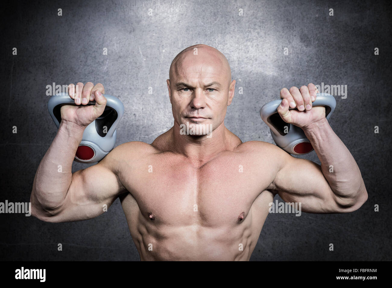 Composite image of portrait of bodybuilder lifting kettlebells Stock