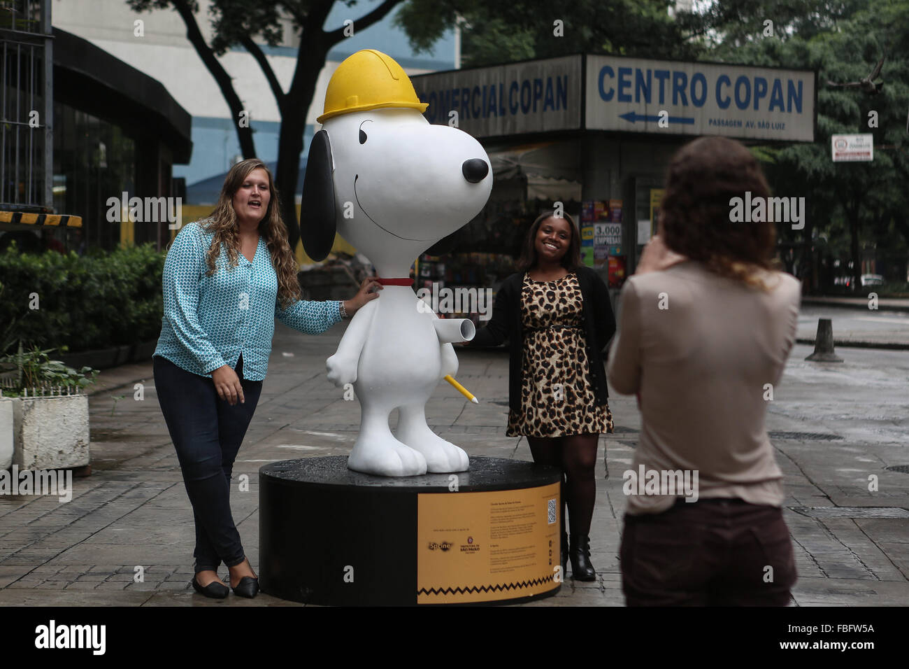 Sao Paulo, Brazil. 15th Jan, 2016. Women pose with a figure of Snoopy on a street in Sao Paulo, Brazil, on Jan. 15, 2016. According to local press, figures of Snoopy are displayed in tourist places as part of the promotion of the film "Charlie Brown and Snoopy: Peanuts movie". © Rahel Patrasso/Xinhua/Alamy Live News Stock Photo